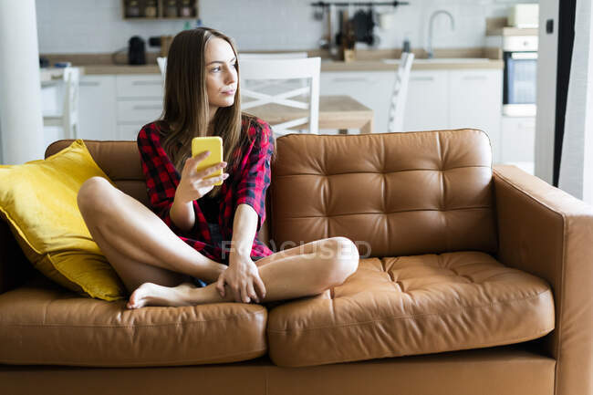 focused_460816526-stock-photo-young-woman-cell-phone-couch